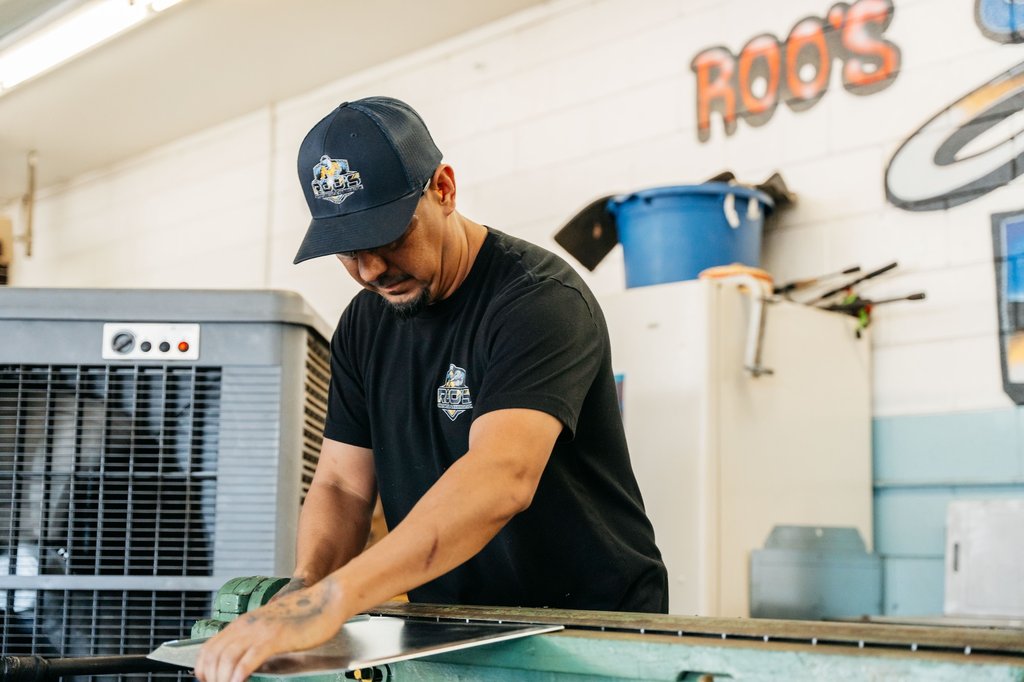 Fabricator working sheet metal on shop equipment