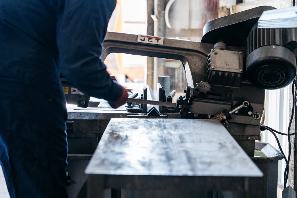 Metal bar being cut on a shop bandsaw