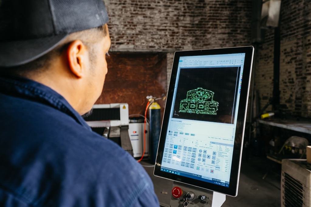 Operator reviewing a laser cutting program on the CNC control screen
