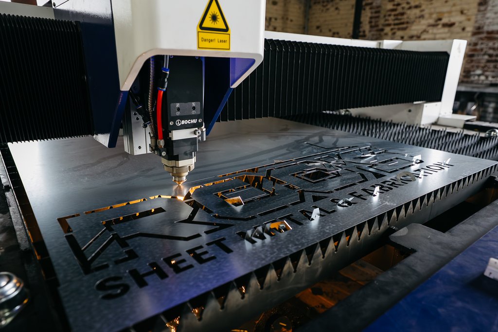 CNC laser cutting a production part from steel plate